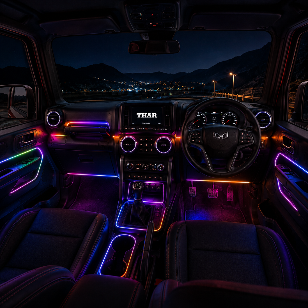 Nighttime cabin perspective view of Mahindra Thar showing custom dashboard, door trim, and footwell RGB ambient light glow.